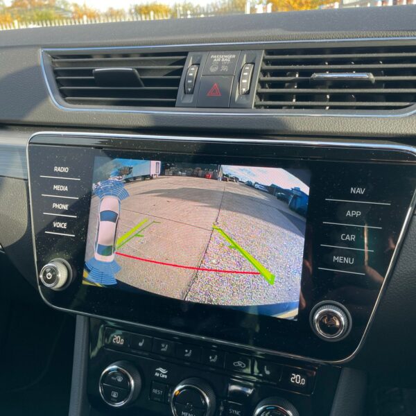 Car dashboard with rear-view camera display and control buttons.
