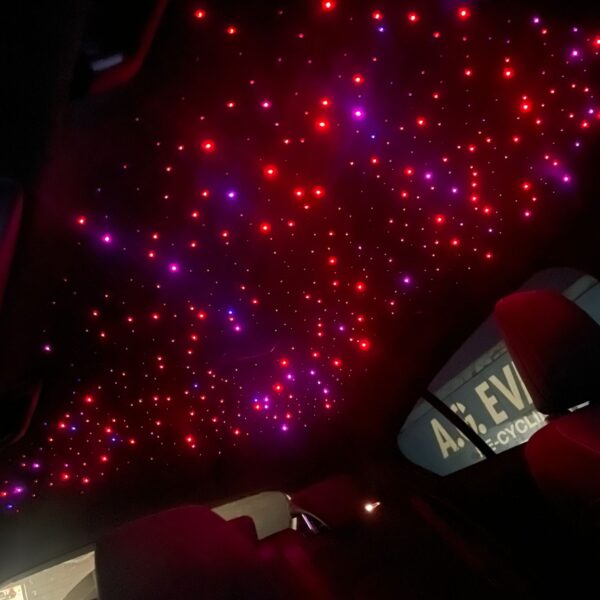 A car interior ceiling featuring red and white LED lights resembling stars.