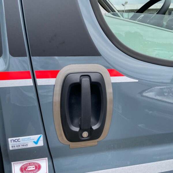 Close-up of a vehicle's sliding door handle with stickers and stripes visible.