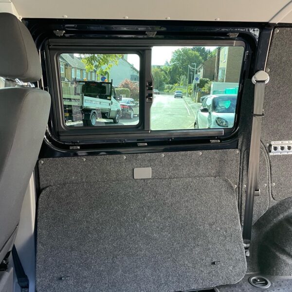 Interior view of a vehicle showing a window with a street view outside.