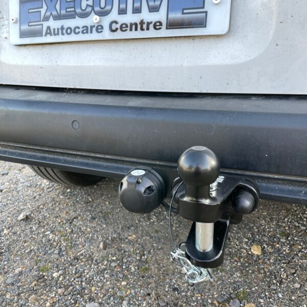 Rear view of a vehicle showing a tow hitch and a license plate with "EXECUTIVE Autocare Centre."