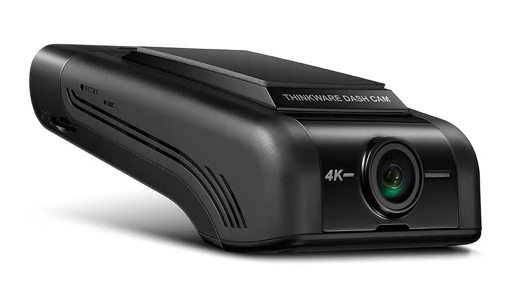 A black, sleek dashcam with a protruding lens and a label on top.